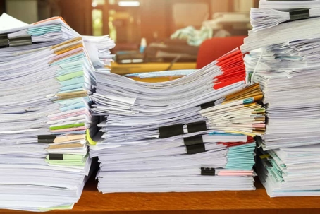 Stacks of documents on a desk in an office