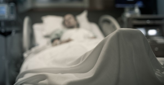 Stressed woman lying in hospital bed getting medical treatment after being involved in a truck accident.