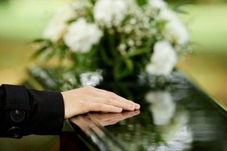 hand placed in a coffin mourning